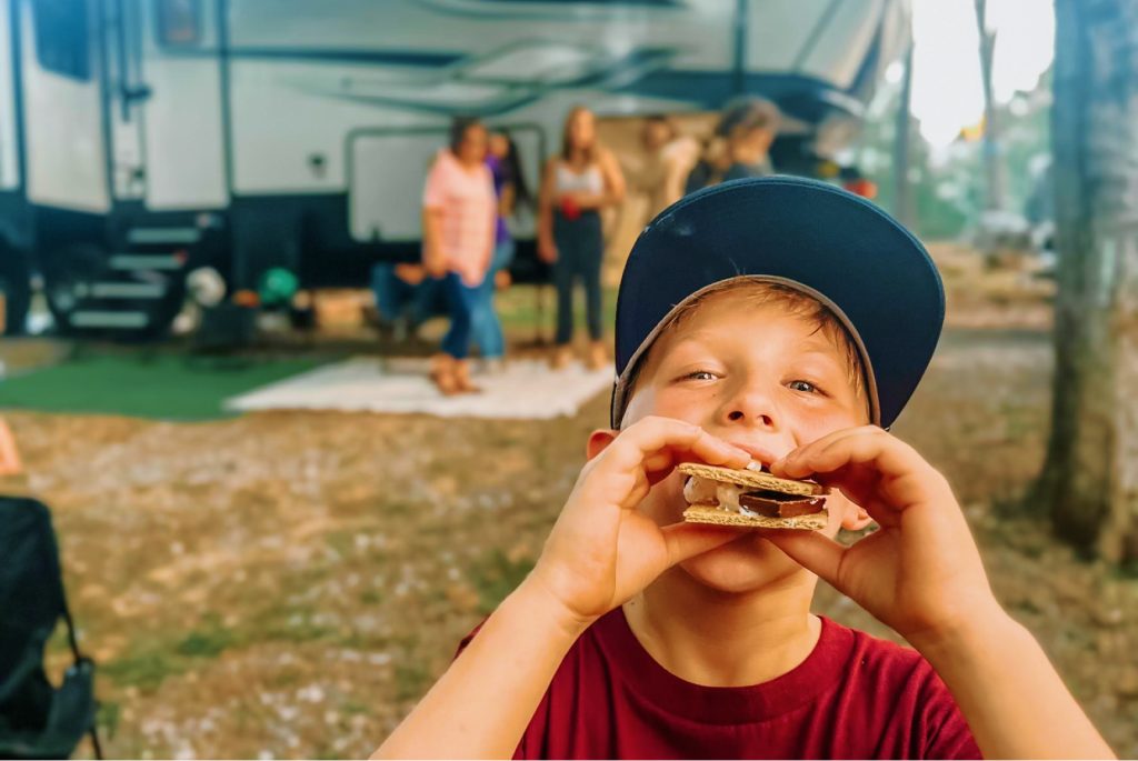 Kid eating s'mores at camp site in Mississippi